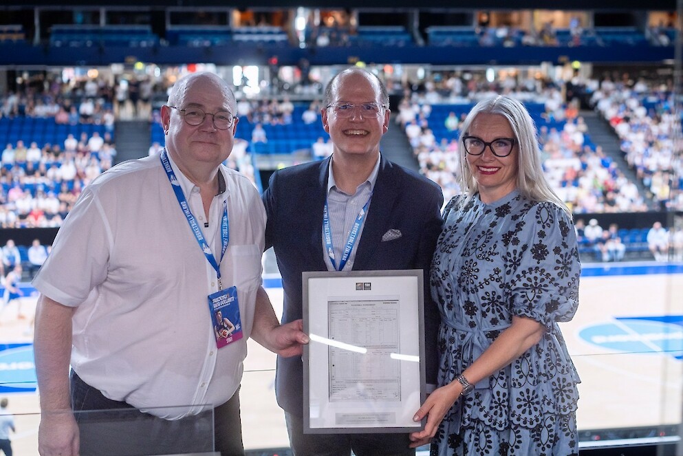 FIBA:n pääsihteeri Andreas Zagklis (keskellä) ojensi Koripalloliiton hallituksen puheenjohtaja Timo Elolle ja toimitusjohtaja Kati Packalénille pöytäkirjan Suomen ensimmäisestä ottelusta vuoden Helsingin olympialaisissa 1952. Vastustajana oli Meksiko, joka vei ottelun luvuin 66-48.