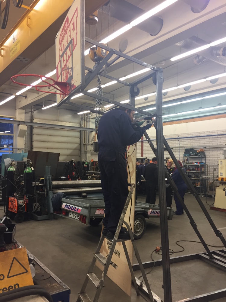 Juha-Matti Peräntie hitsaamassa saranoita paikalleen.